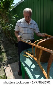 Grandfather Repairs A Chair On The Street, Using Screws, Glue, And A Vice.