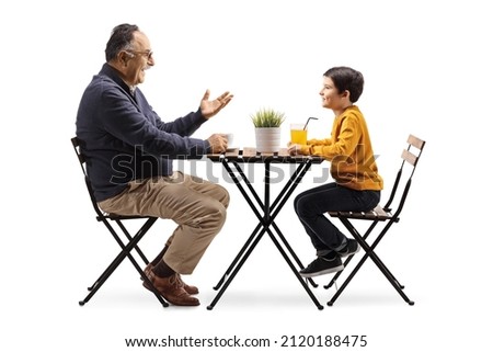 Grandfather sitting at a cafe table and talking to a grandson isolated on white background