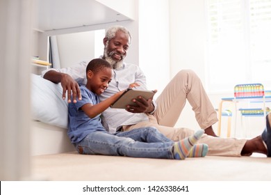 Grandfather Sitting With Grandson In Childs Bedroom Using Digital Tablet Together - Powered by Shutterstock