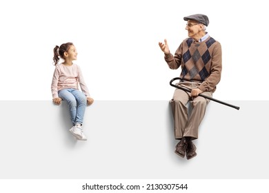 Grandfather sitting on a blank panel and talking to a little girl isolated on white background