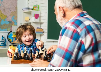 Grandfather Son Playing Chess, Happy Men Generations Family. Old Grandfather And Cute Little Boy Grandson Study And Learn Together. Senior Grandpa Playing Chess.