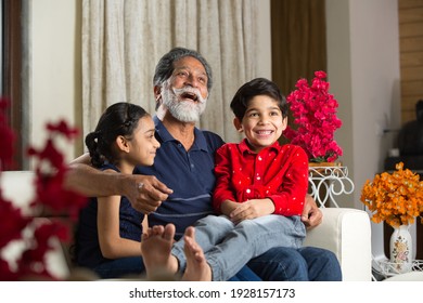 Grandfather Spending Leisure Time With Grandkids At Living Room