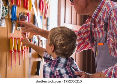 Grandfather Teaches Boy To Work On Bench With Joinery Tools