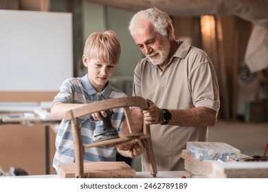 A grandfather teaches his grandson how to fix furniture in his carpenter workshop. They work together, sharing tools and skills, as the grandfather passes on his knowledge.
 - Powered by Shutterstock