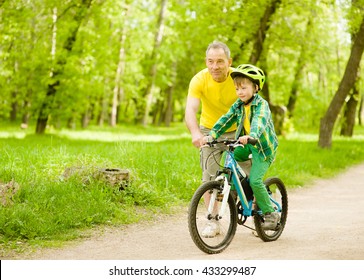 Grandfather Teaches His Grandson To Ride A Bike.