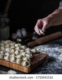 Grandma Cooks Dumplings On A Dark Table.