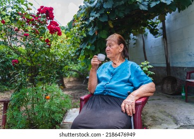 Grandma Drinking Coffee Outside In Her House Garden During The Day