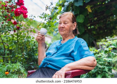 Grandma Drinking Coffee Outside In Her House Garden During The Day