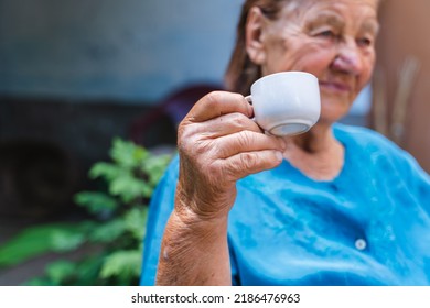 Grandma Drinking Coffee Outside In Her House Garden During The Day