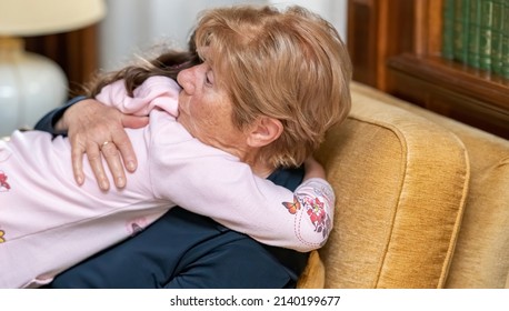 Grandma And Grand Daughter Embracing At Home For Mother's Day.