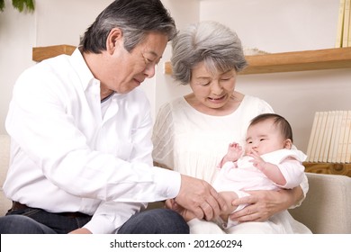 A Grandma And A Granddad Babysitting Their Granddaughter