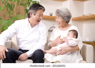 A Grandma And A Granddad Babysitting Their Granddaughter