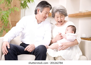 A Grandma And A Granddad Babysitting Their Granddaughter