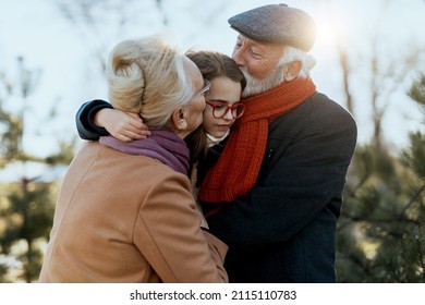 Grandma And Grandpa Enjoy With Their Sweet Granddaughter On A Sunny Winter Day.