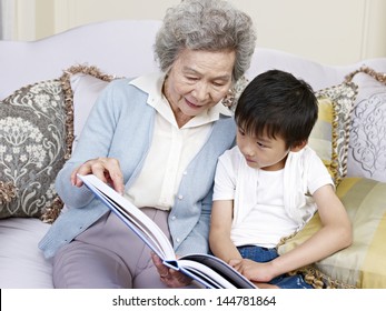 Grandma And Grandson Reading A Book Together.