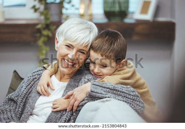 Grandma and\
grandson spend beautiful time together, they are happy and enjoy\
themselves. The child hugs her with a lot of love. Happy\
grandmother with her grandson in the\
house.