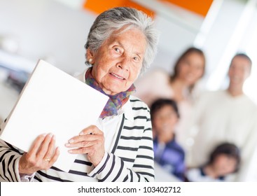 Grandma Holding A Book Of Cooking Recipes