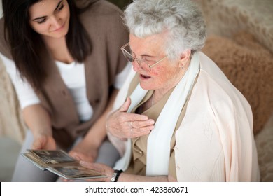 Grandma Showing Old Photo Album To Her Granddaughter