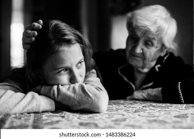 Grandma Stroking The Head Crying Granddaughter. Black And White Photo.