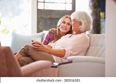 Grandmother With Adult Granddaughter Relaxing On Sofa - Powered by Shutterstock