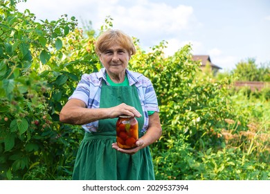 Grandmother Canning Tomatoes For The Winter. Selective Focus. Food.