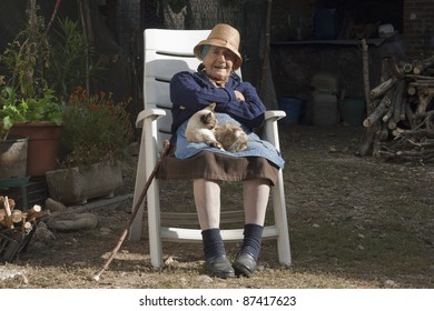grandmother with a cat sitting  in the open on a sunny afternoon
