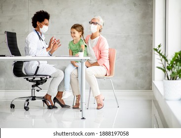 Grandmother With Cute Grandaughter Black Female Doctor In The Office