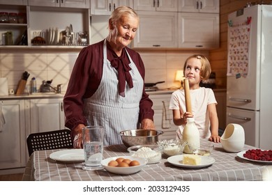 Grandmother Giving A Cooking Lesson To Her Granddaughter