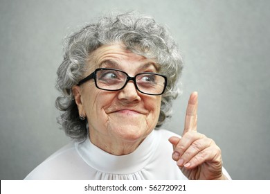 Grandmother in glasses points a finger up