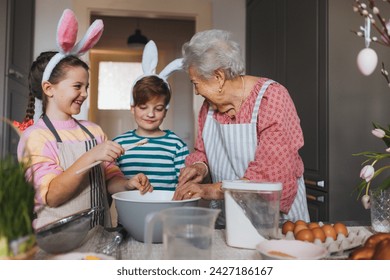 Grandmother with grandchildren preparing traditional easter meals, baking cakes and sweets. Passing down family recipes, custom and stories. - Powered by Shutterstock