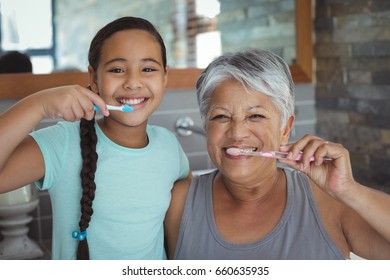 Grandmother and granddaughter brushing teeth in the bathroom at home