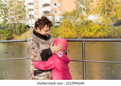 Grandmother And Granddaughter Hugging. Having Good Times With Grandparent In Autumn Park