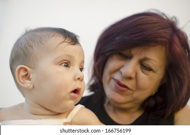 Grandmother And Granddaughter Portrait. Focus Is On Baby