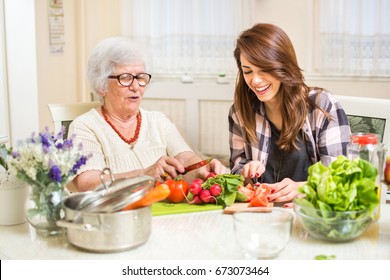 Grandmother and granddaughter preparing food at home. - Powered by Shutterstock