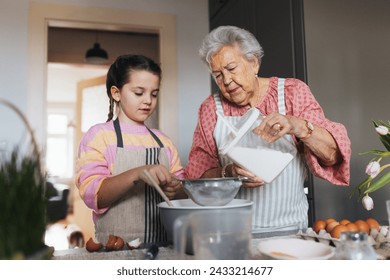 Grandmother with granddaughter preparing traditional easter meals, baking cakes and sweets. Passing down family recipes, custom and stories. - Powered by Shutterstock