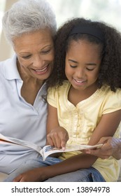 Grandmother And Granddaughter Reading And Smiling