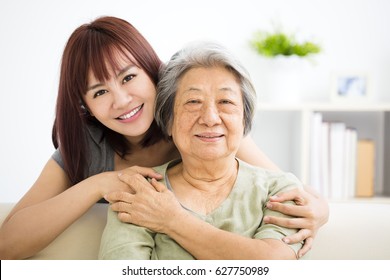 Grandmother and granddaughter. Young woman carefully takes care of old woman