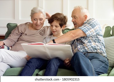 Grandmother with grandfather and grandson together. Grandfather shows something in the book to his grandson
