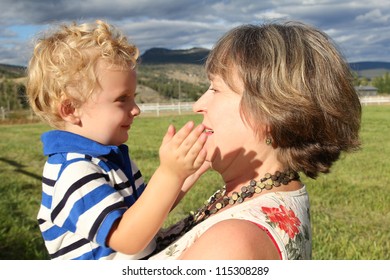 Grandmother And Grandson Playing Outside In The Field