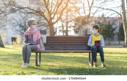 Grandmother and grandson separated by social distancing on park bench - Powered by Shutterstock