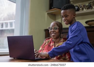 Grandmother with grandson using laptop at home - Powered by Shutterstock