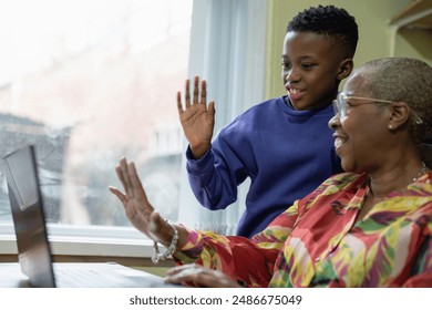 Grandmother with grandson using laptop at home - Powered by Shutterstock