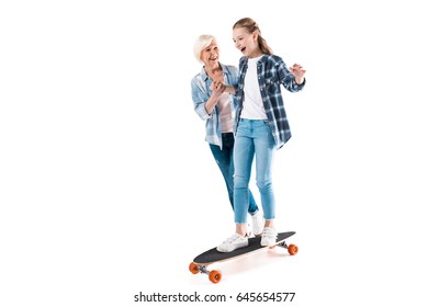 Grandmother And Happy Granddaughter With Skateboard Isolated On White In Studio