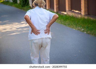 The Grandmother Has An Old Woman With A Backache. Selective Focus. Street.