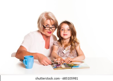 Grandmother And Her Little Cute Granddaughter Reading A Book On White Background