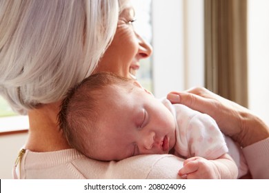 Grandmother Holding Sleeping Newborn Baby Granddaughter - Powered by Shutterstock