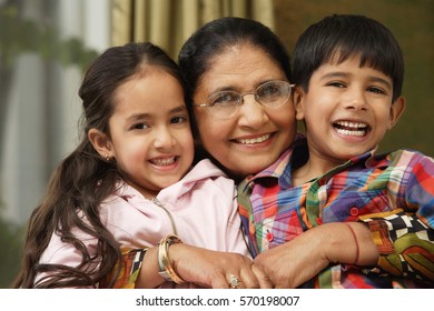 Grandmother Hugs Grandkids, All Smile At Camera