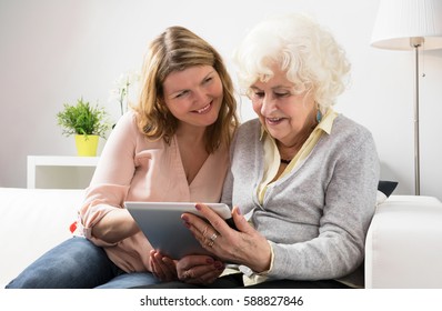 Grandmother Learning How To Use Tablet 