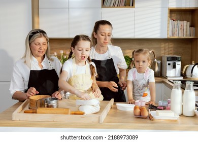 Grandmother Mom And Daughters Cooking Baking Cake Older Daughter Taking Flour Pouring Into Vessel Mother Giving Orders Preschooler Daughter. Granny Watching Process. Family Having Fun.