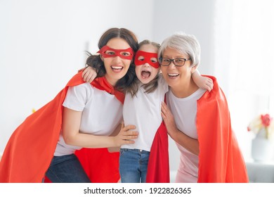 Grandmother, mother and child playing together. Girl and women in Superhero costumes. Family holiday and togetherness. - Powered by Shutterstock